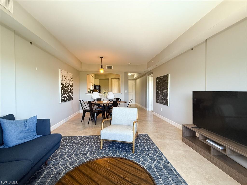 1100 Pine Ridge Road, Unit B405 Naples, FL 34108 - Photo 24 of 43 a living room with furniture and a flat screen tv