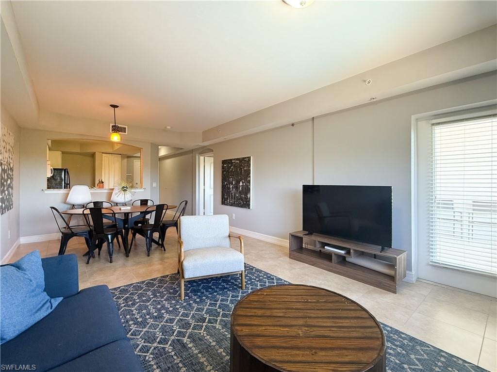 1100 Pine Ridge Road, Unit B405 Naples, FL 34108 - Photo 25 of 43 a living room with furniture and a flat screen tv