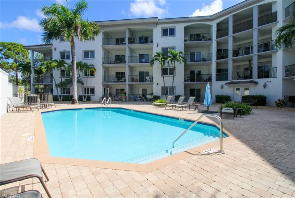 1100 Pine Ridge Road, Unit B405 Naples, FL 34108 - Photo 40 of 43 a swimming pool with outdoor seating and yard