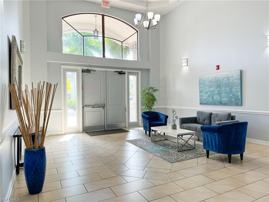 1100 Pine Ridge Road, Unit B405 Naples, FL 34108 - Photo 9 of 43 a living room with furniture a fireplace and a chandelier