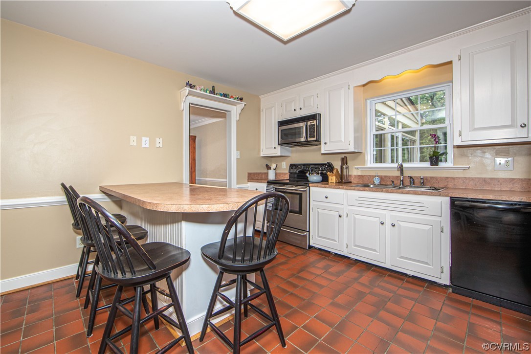 13371 Kingsmill Road Midlothian, VA 23113 - Photo 8 of 43 a kitchen with stainless steel appliances a white table and chairs