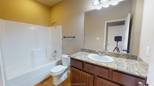 a bathroom with a granite countertop sink toilet and shower