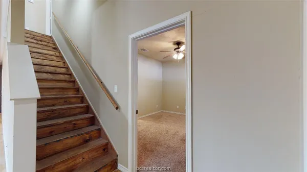 a view of a hallway with wooden floor and entryway