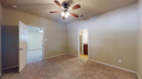 an empty room with closet and a ceiling fan