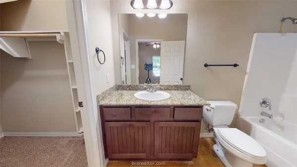 a bathroom with a granite countertop sink toilet and shower