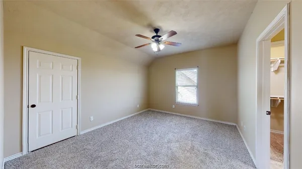 a view of empty room with window and ceiling fan