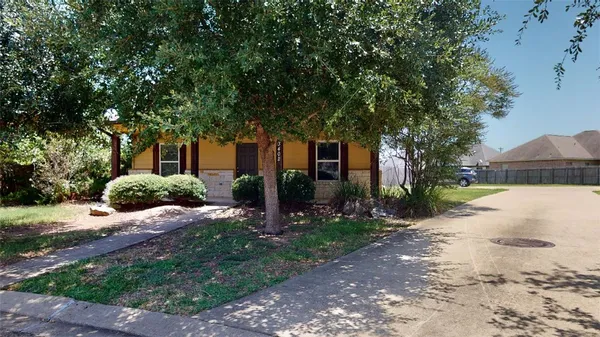 a front view of a house with a yard and trees
