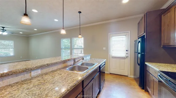 a kitchen with kitchen island a sink stove and refrigerator