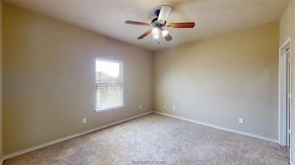 an empty room with a window and a fan