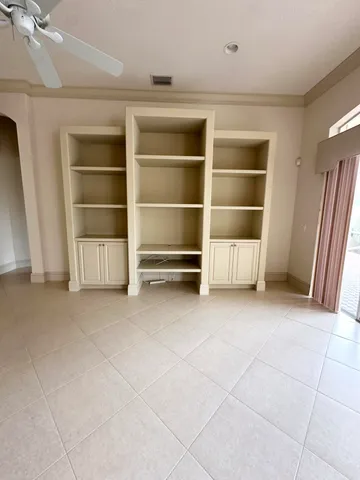 a view of an empty room with a fireplace and a cabinets