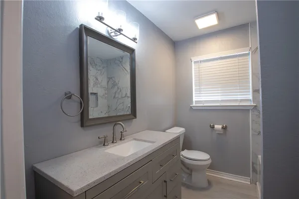 a bathroom with a toilet sink and mirror