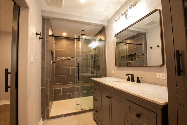 a bathroom with a shower sink and mirror