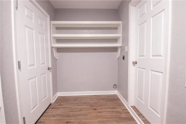 a view of a hallway with wooden floor and entryway