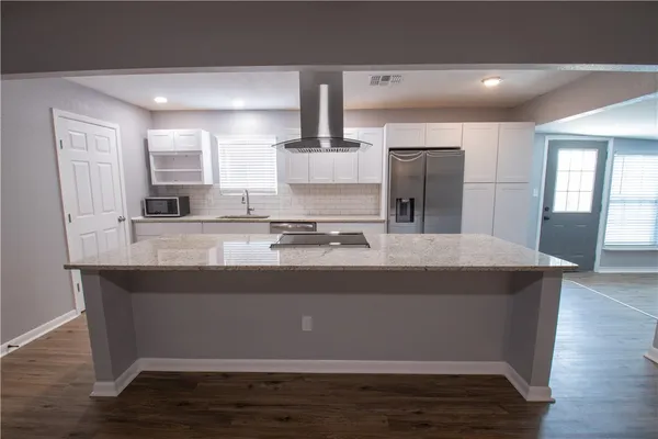 a view of kitchen with stainless steel appliances granite countertop sink and wooden floor