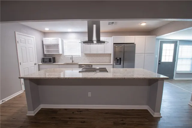 a view of kitchen with stainless steel appliances granite countertop sink and wooden floor