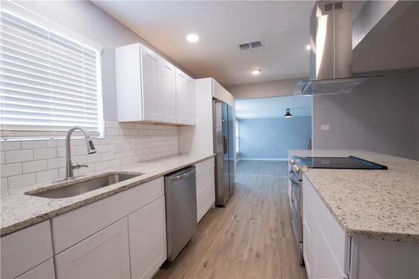 a kitchen with a sink stove and cabinets