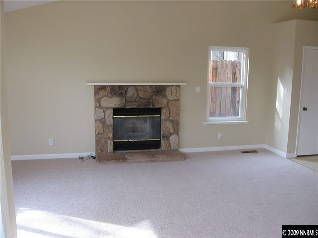 6154 Chesterfield Lane Reno, NV 89523 - Photo 2 of 9 an empty room with windows and fireplace