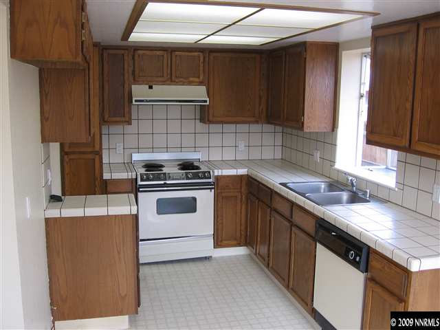 6154 Chesterfield Lane Reno, NV 89523 - Photo 4 of 9 a kitchen with granite countertop a sink stove and cabinets