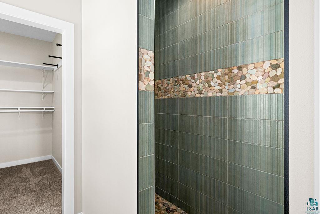 2236 Hoover Street Duluth, MN 55811 - Photo 18 of 52 Bathroom featuring dark carpet, a spacious closet, and a tile shower