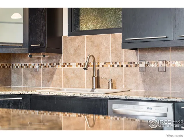 a kitchen with stainless steel appliances granite countertop a sink and a refrigerator