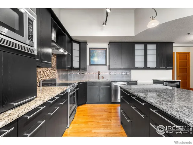 a kitchen with stainless steel appliances granite countertop a sink stove and cabinets