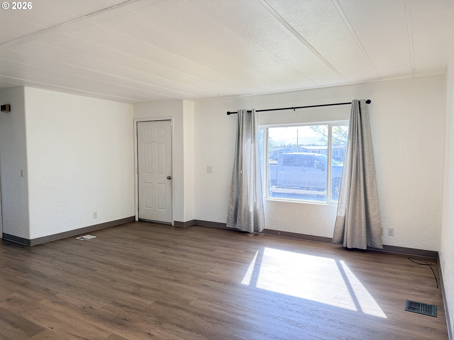 1330 West Sunland Avenue Hermiston, OR 97838 - Photo 2 of 23 an empty room with wooden floor and windows