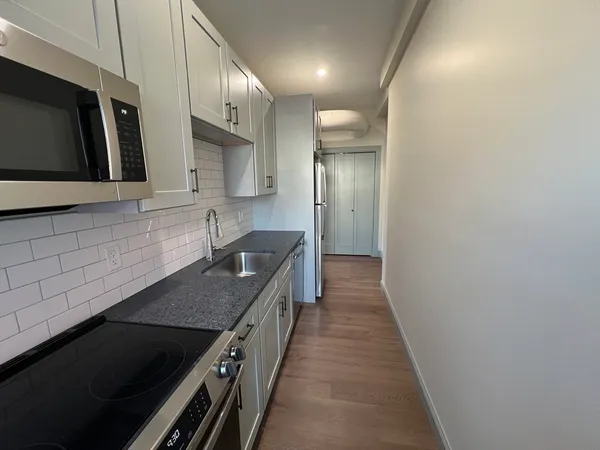 a kitchen with stainless steel appliances granite countertop a sink and a stove