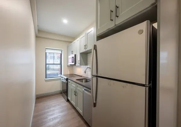 a white refrigerator freezer and a stove sitting inside of a kitchen