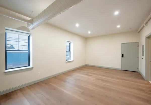 an empty room with windows and closet