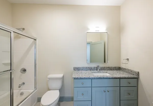 a bathroom with a granite countertop sink toilet and shower
