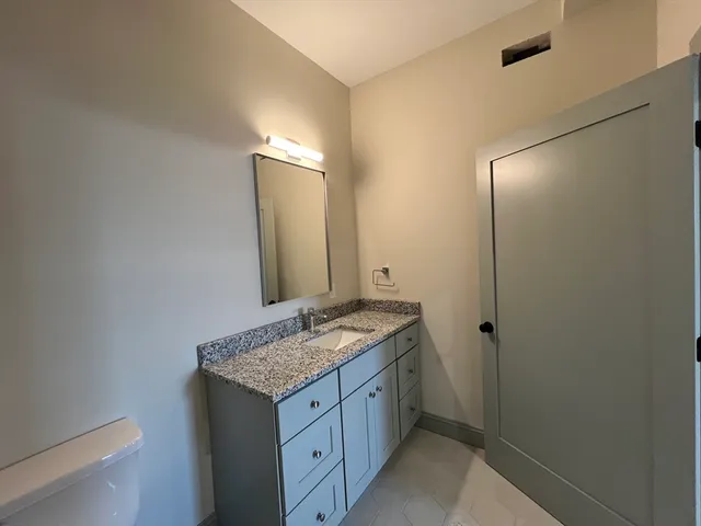 a bathroom with a granite countertop sink and a mirror