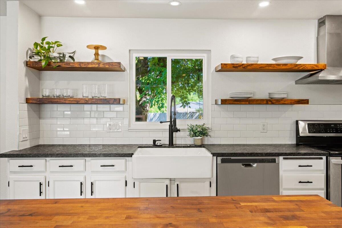2041 Athens Avenue Redding, CA 96001 - Photo 11 of 36 a kitchen with granite countertop a stove a sink and a microwave