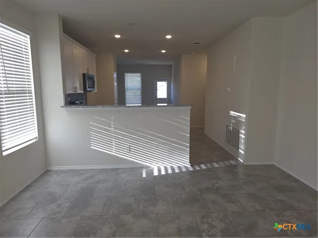 a view of a hallway with stairs and a window