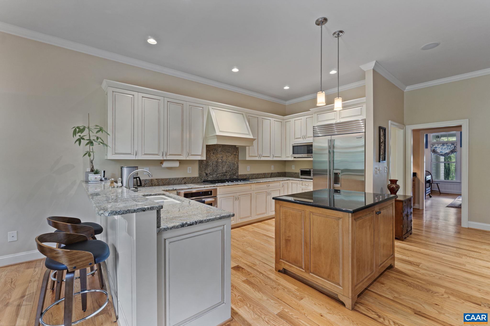 2025 Farringdon Road Keswick, VA 22947 - Photo 12 of 55 a kitchen with stainless steel appliances granite countertop a stove top oven a sink dishwasher a dining table and chairs with wooden floor
