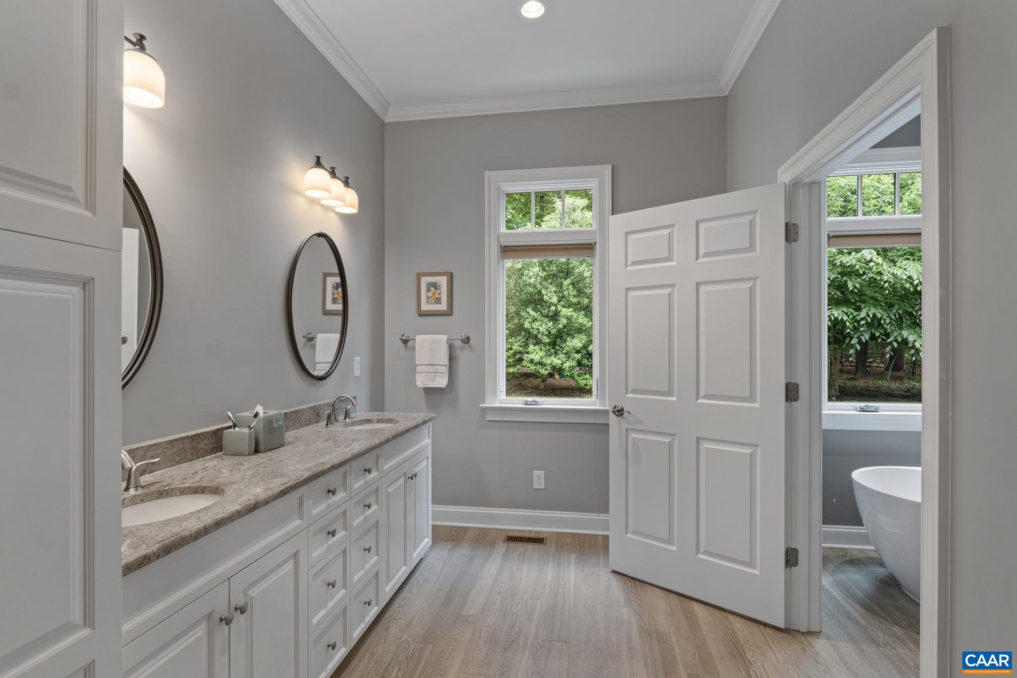 2025 Farringdon Road Keswick, VA 22947 - Photo 26 of 55 a spacious bathroom with a granite countertop toilet a sink and a mirror