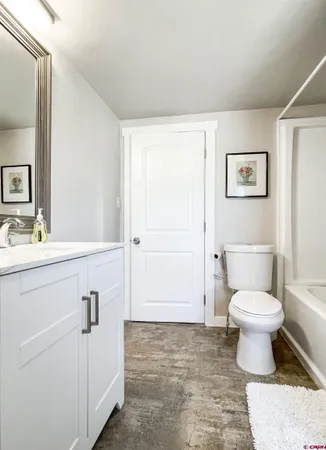 a bathroom with a toilet sink vanity and mirror