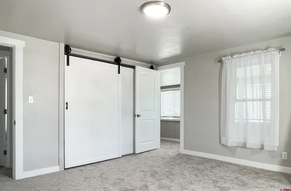 an empty room with windows and closet