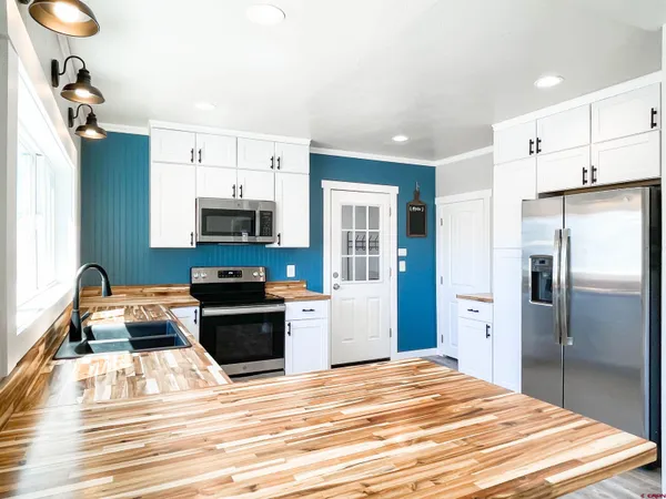 a kitchen with granite countertop a refrigerator and a stove top oven