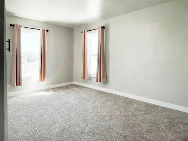 an empty room with windows and closet
