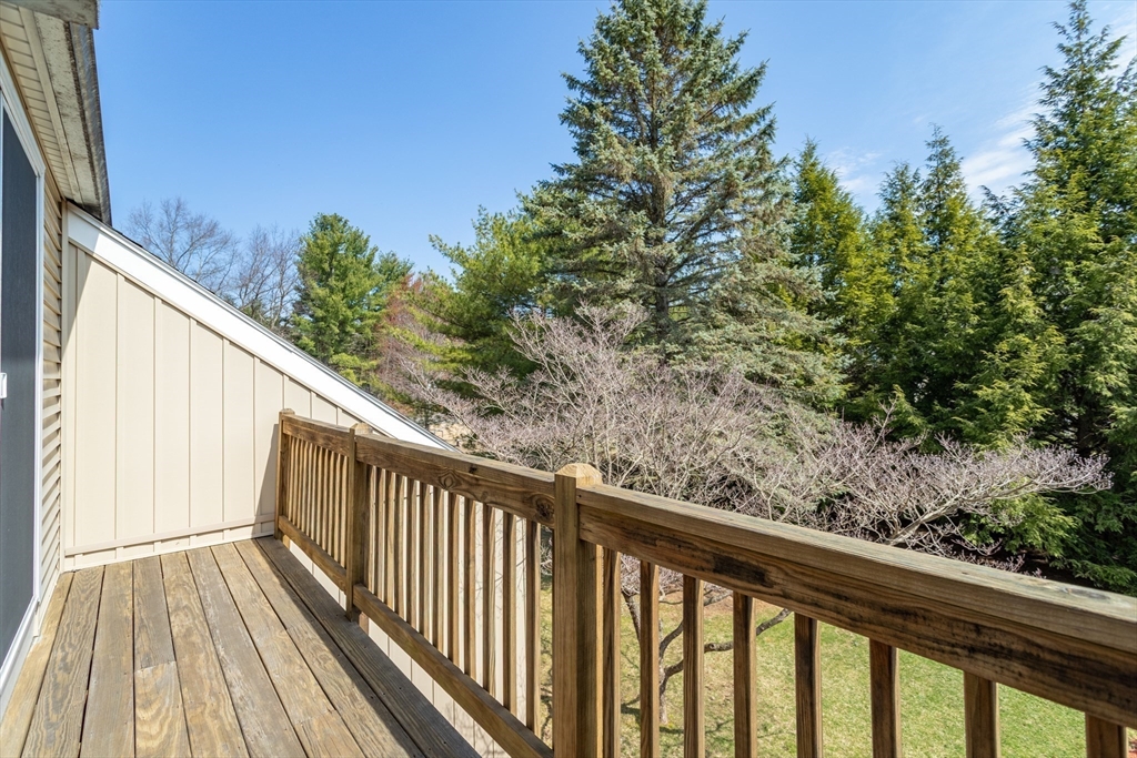 164 Ayer Road, Unit F4 Shirley, MA 01464 - Photo 16 of 34 a view of a balcony with wooden floor and fence