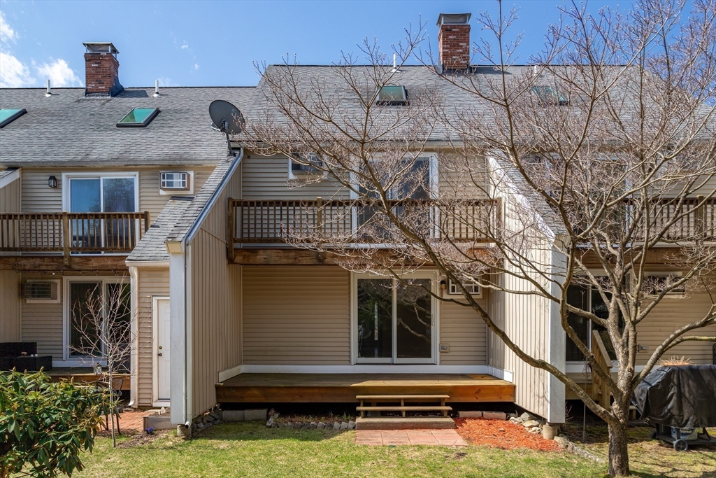 164 Ayer Road, Unit F4 Shirley, MA 01464 - Photo 28 of 34 a view of a white house with large windows and a small yard
