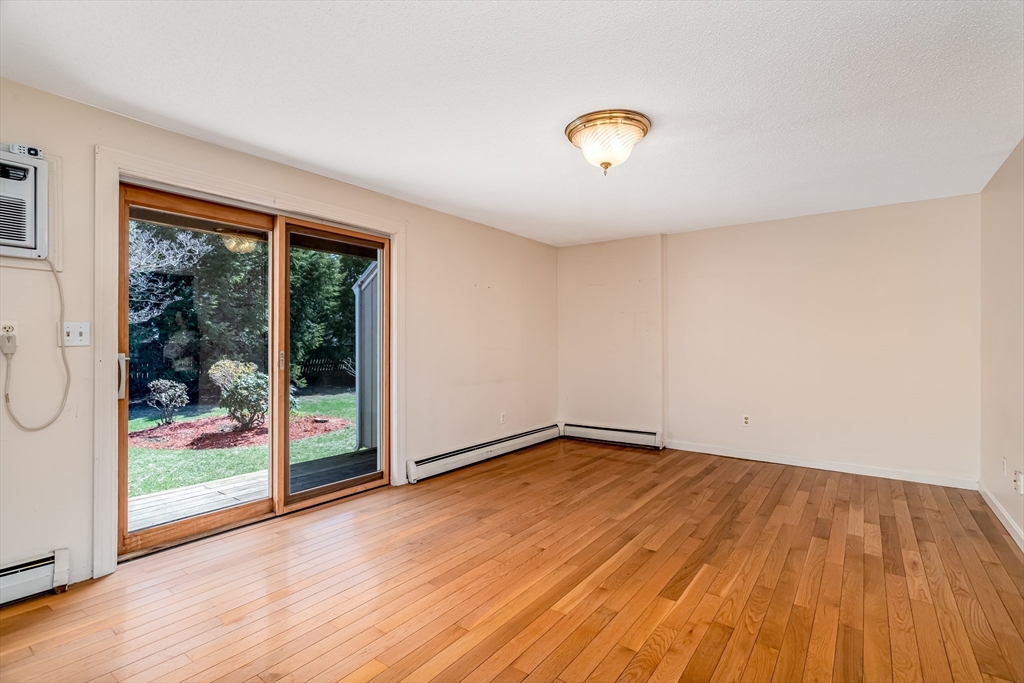 164 Ayer Road, Unit F4 Shirley, MA 01464 - Photo 7 of 34 a view of an empty room with wooden floor and a window