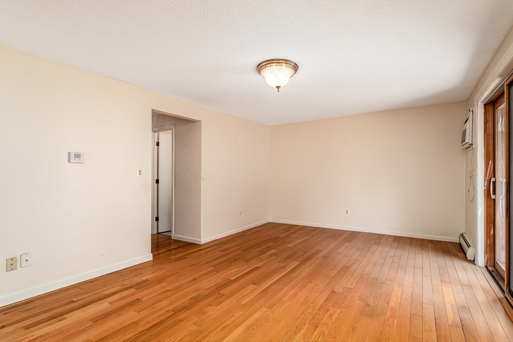 164 Ayer Road, Unit F4 Shirley, MA 01464 - Photo 8 of 34 an empty room with wooden floor and windows