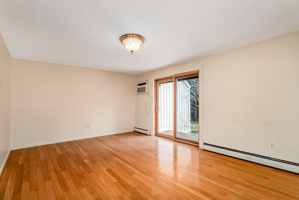 164 Ayer Road, Unit F4 Shirley, MA 01464 - Photo 9 of 34 an empty room with wooden floor and windows