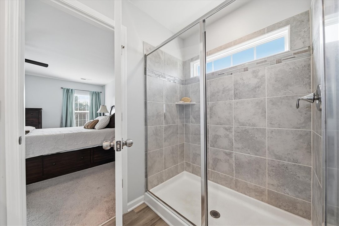 208 Grassy Creek Way Pendleton, SC 29670 - Photo 29 of 43 A well-appointed shower stall features tiled walls and an overhead window for natural light.