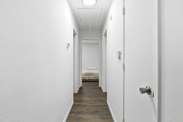 a view of a hallway with wooden floor and staircase