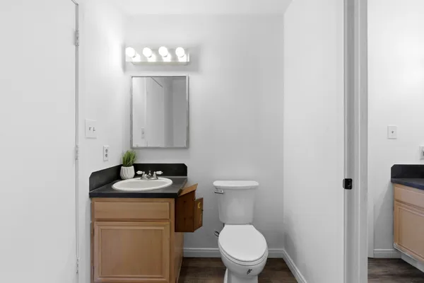 a bathroom with a granite countertop toilet and a sink