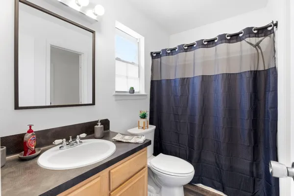 a bathroom with a sink vanity mirror and toilet