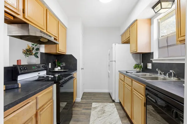 a kitchen with stainless steel appliances granite countertop a sink stove and refrigerator