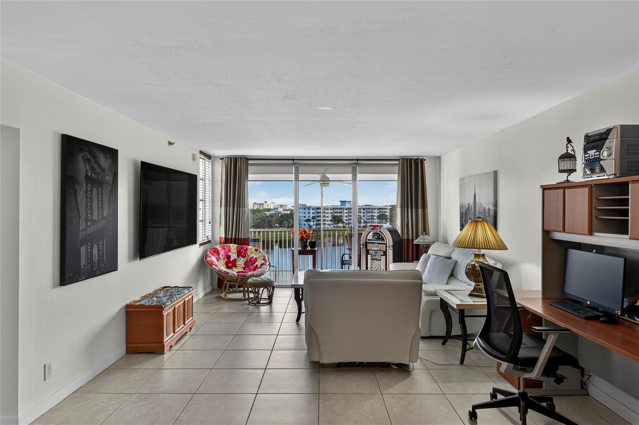 2900 North Course Drive, Unit 607 Pompano Beach, FL 33069 - Photo 22 of 48 a living room with furniture a large window and a flat screen tv